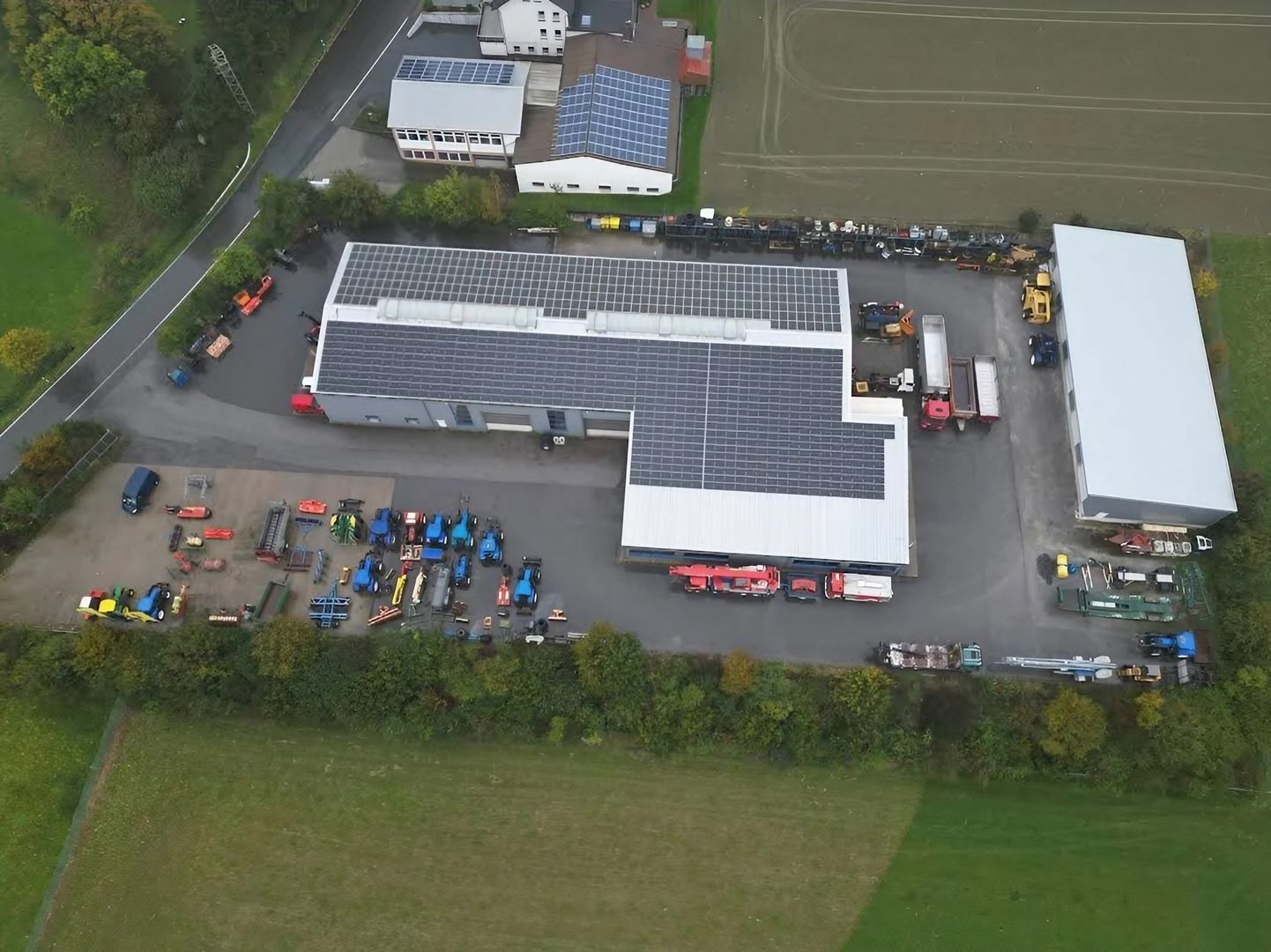 Luftaufnahme von eines großen Lagers mit Solarpanelen auf dem Dach, das nachhaltige Energieerzeugung zeigt